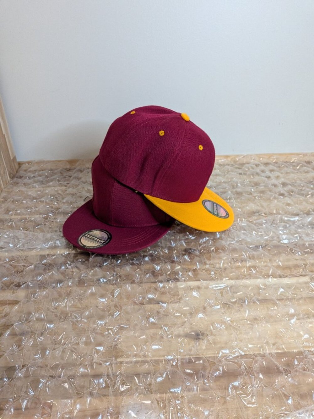 Burgandy and yellow baseball caps.